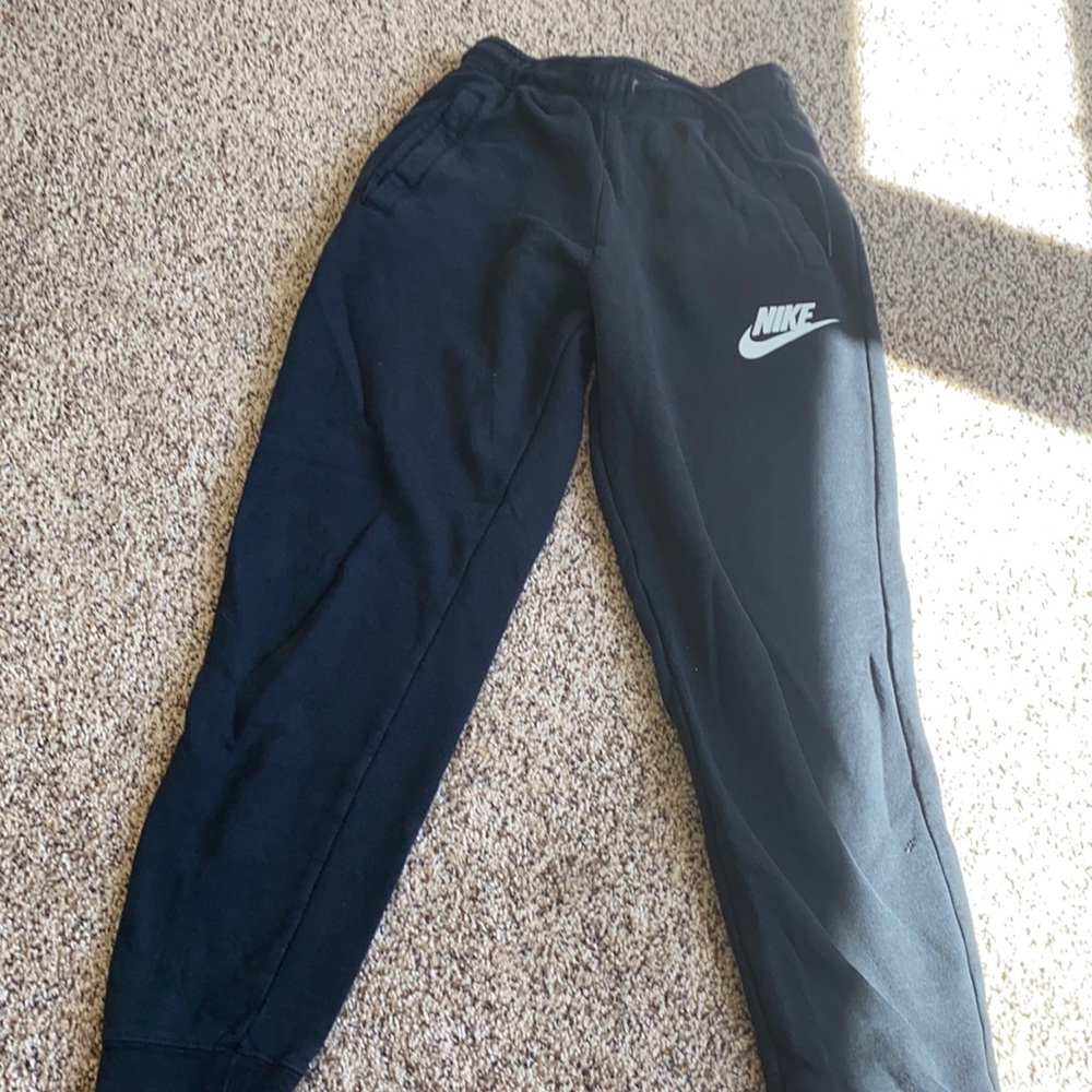 Black nike sweatpants with a tiny hole